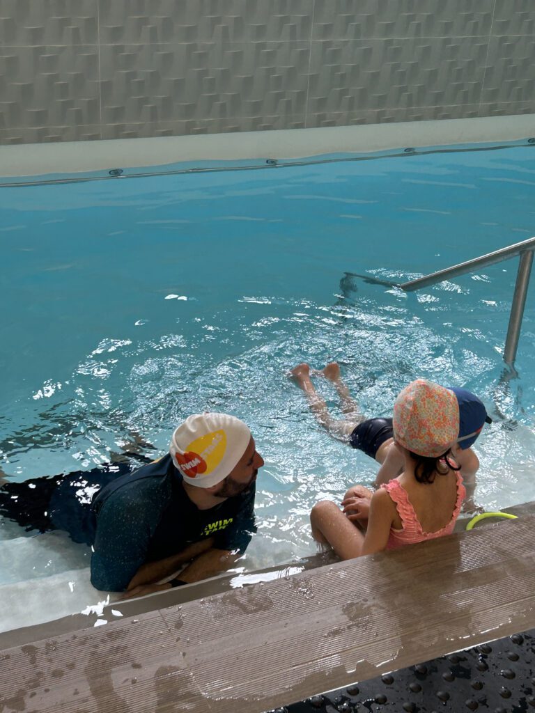 Coach de natation aidant un jeune nageur à Meudon la Forêt